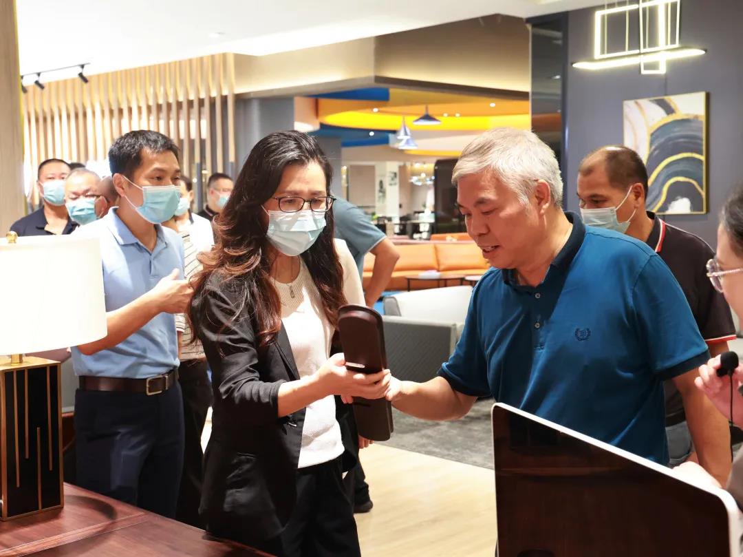 911香蕉视频APP家具集團董事副總裁黃雲林為調研組展示實木辦公家具產品